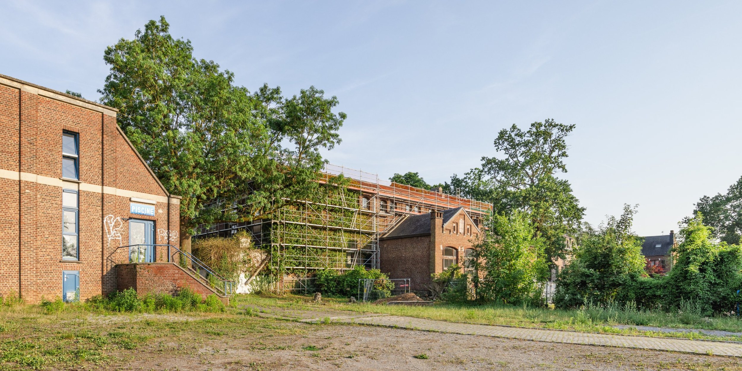 Rénovation d'un bâtiment en brique avec échafaudages – Atelier des Aires