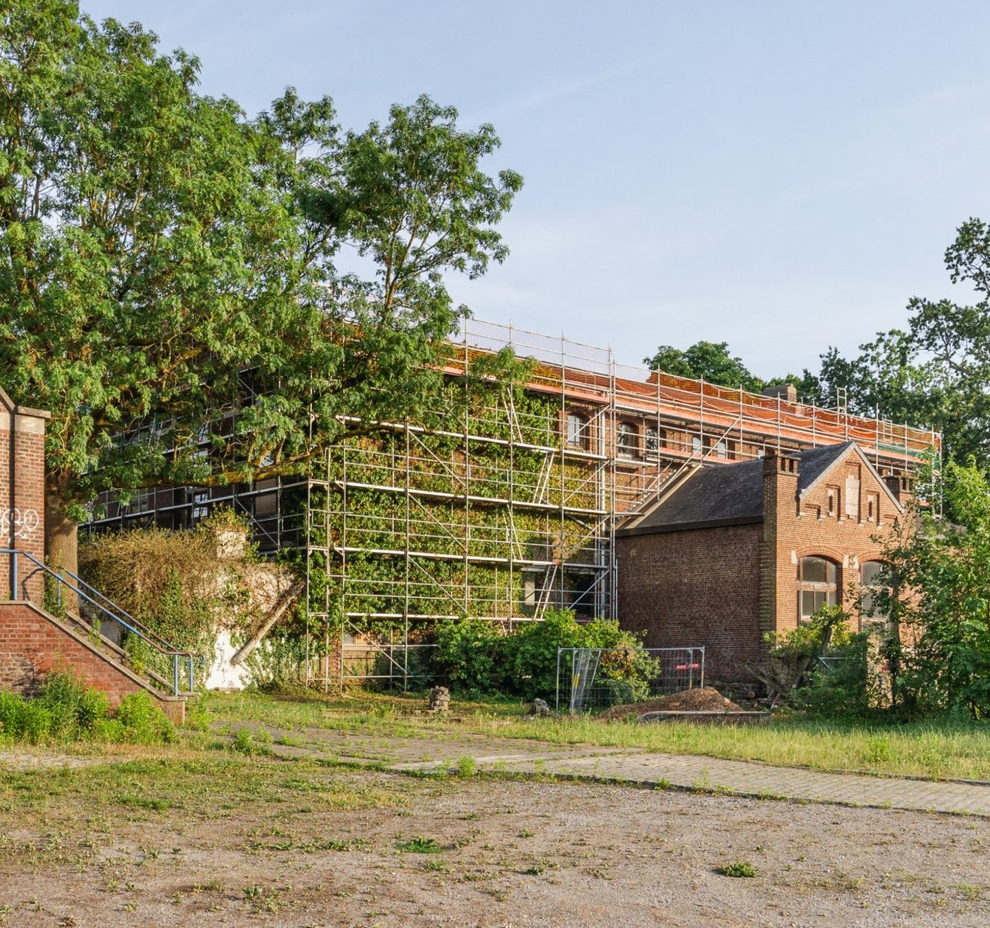 Rénovation d'un bâtiment en brique avec échafaudages – Atelier des Aires